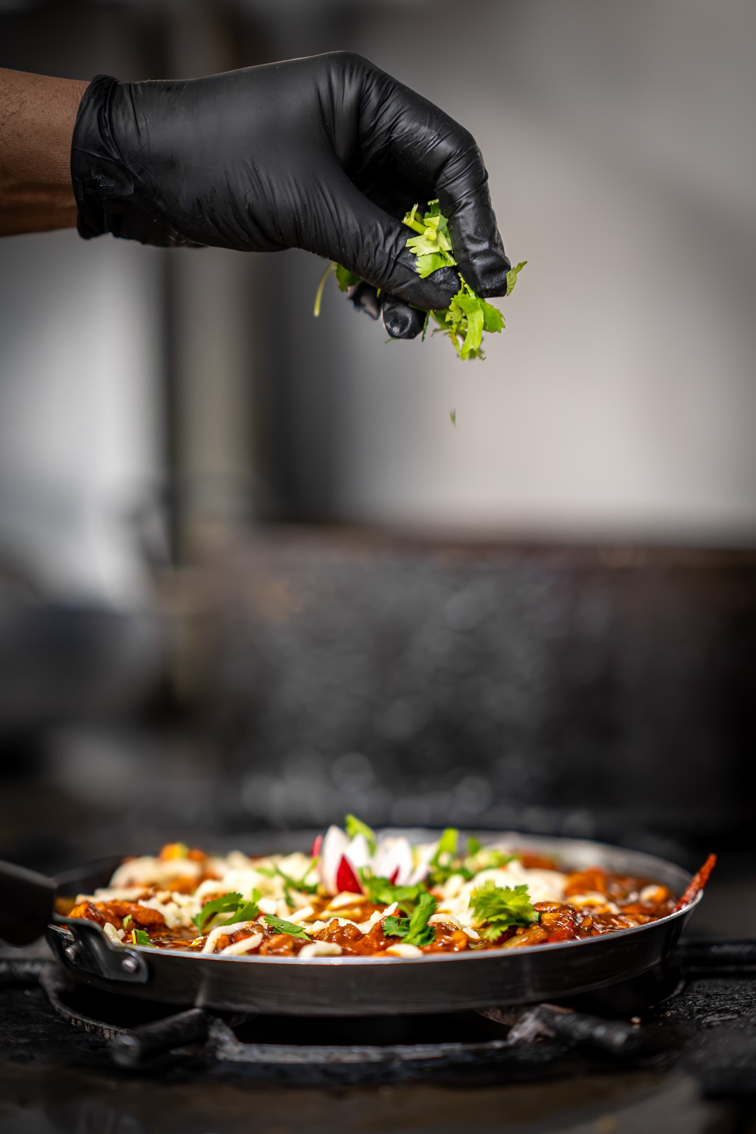 Fresh coriander garnishing a curry in the pan