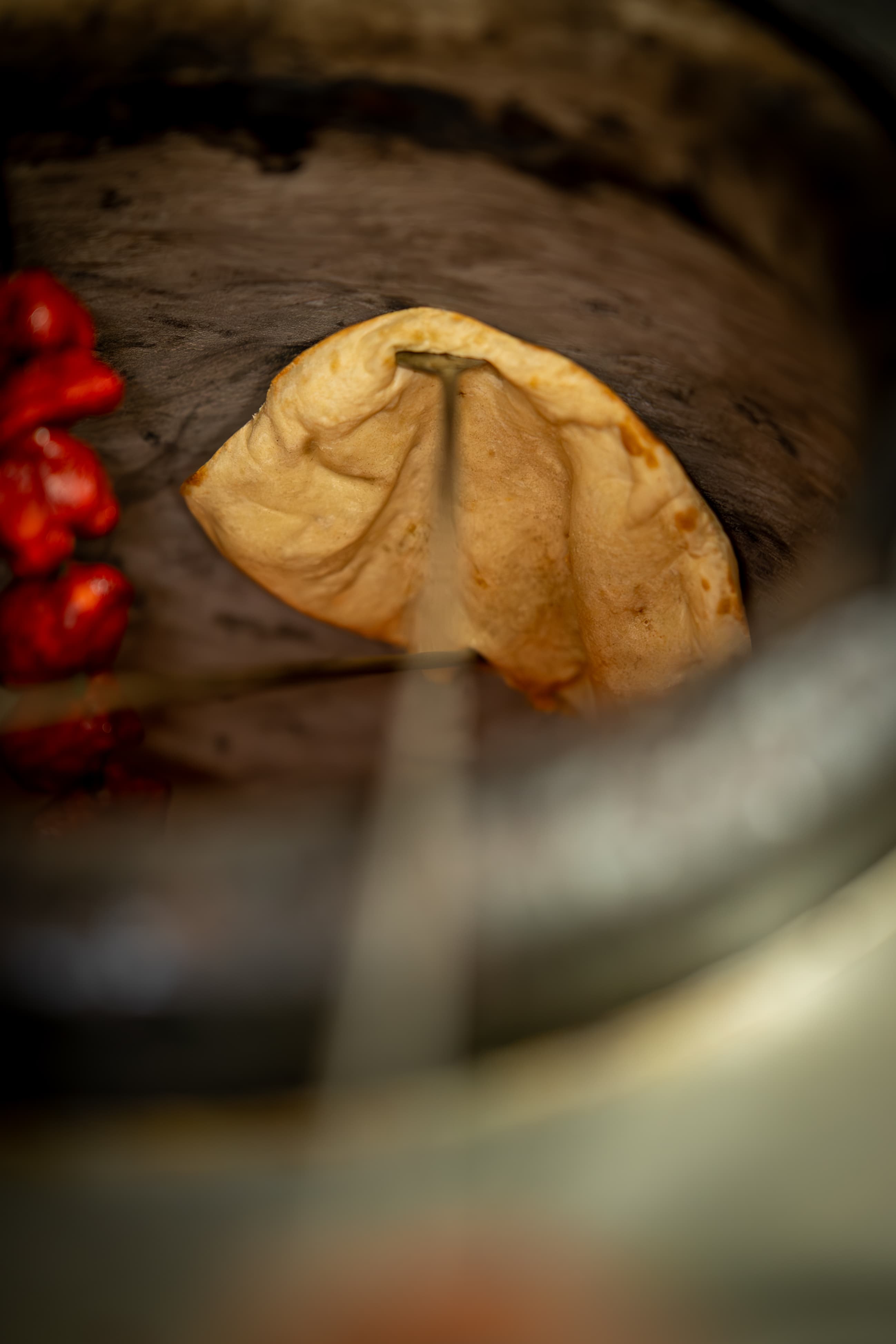 Naan bread baking on the wall of the tandoor oven