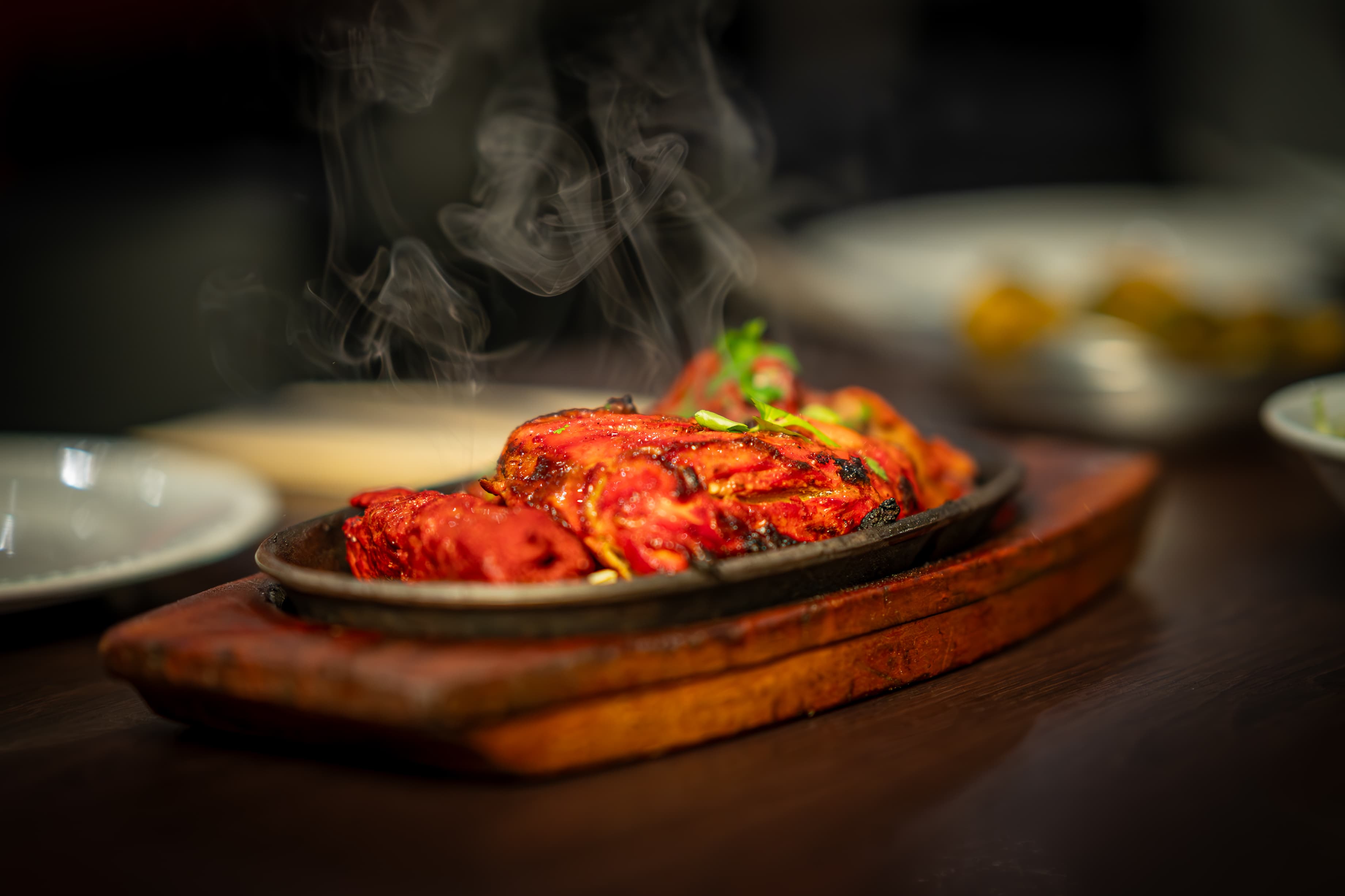Sizzling tandoori dish with rising steam